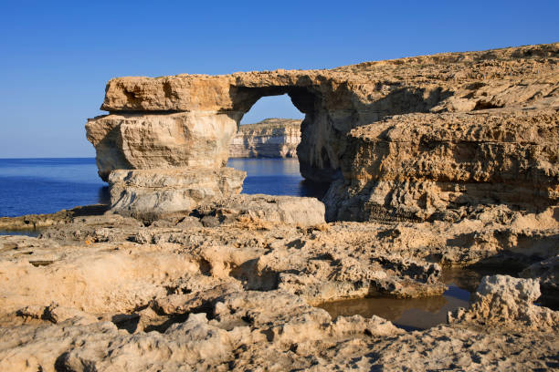 High Cliffs of Malta Island with a view of the sea on which a boat is sailing