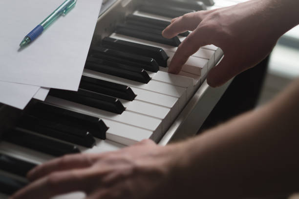 istock Piano lessons, coaching, teaching or training concept. Talented pianist showing example with digital music instrument. Intimate and cinematic view of male hands on keys. Man playing keyboard. 691580218