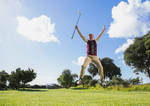 istock Excited golfer jumping up holding club 691580298
