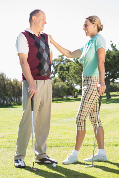 istock Golfing couple standing smiling at each other 691582512