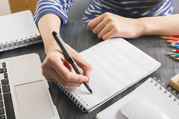 istock Woman writing in notepad closeup 691589268