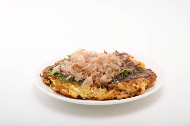okonomiyaki pancake giapponese su piatto su sfondo bianco - okonomiyaki foto e immagini stock