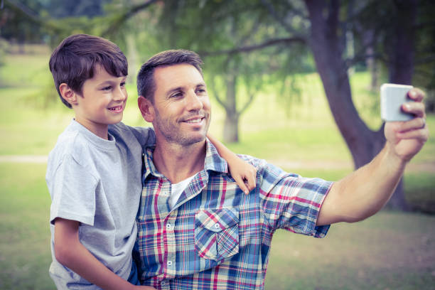 istock Father and son taking a selfie in the park 691606670