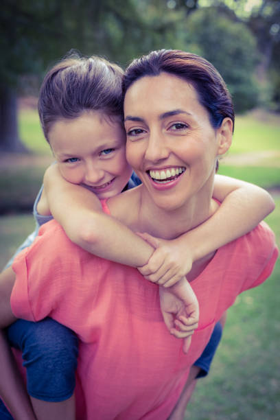 Happy mother and daughter making a heart sign with their hands at home