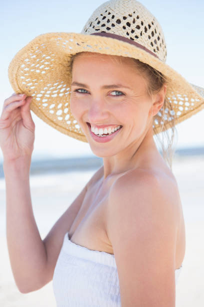 istock Pretty smiling blonde on the beach wearing straw hat 691609946