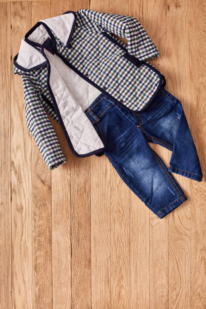 istock Children's jeans and jacket on wooden background. 691610022
