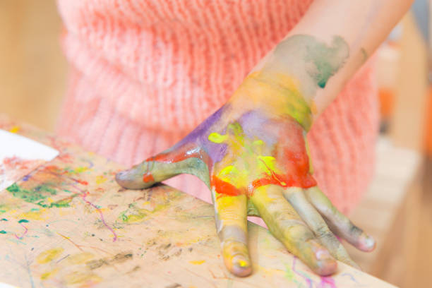 istock girl drawing paints on paper and hands 691615942