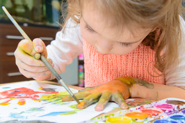 istock girl drawing paints on paper and hands 691616006
