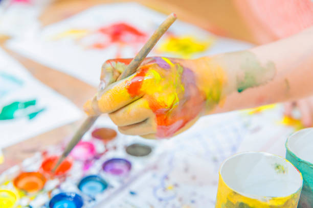 istock girl drawing paints on paper and hands 691616280