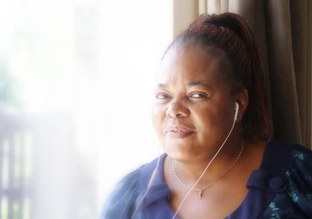 istock mature woman at home using earphones 691620528