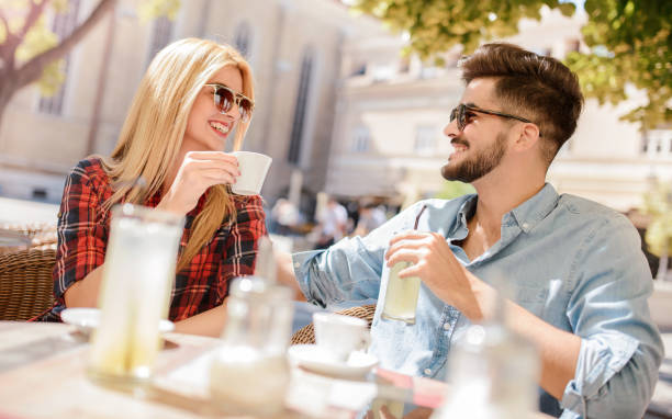 pareja romántica bebiendo café y limonada, tener una cita en el café. citas, amor, relaciones - whispering couple discussion smiling fotografías e imágenes de stock