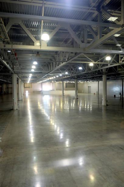 istock Large empty warehouse inside in industrial building with a high ceiling and artificial lighting 691659278