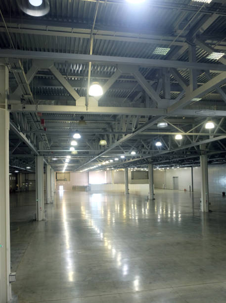istock Large empty warehouse inside in industrial building with a high ceiling and artificial lighting 691659288