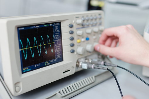 Student exprimenting with an Oscilloscope  in the university