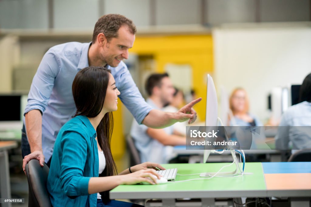 Aider les élèves à une classe d’informatique des enseignants - Photo de Professeur d'université libre de droits