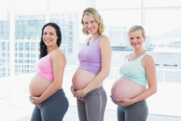 istock Happy pregnant women standing in a row 691694064