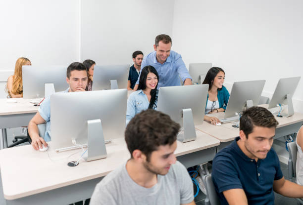 istock Happy teacher helping student at an IT class 691703562