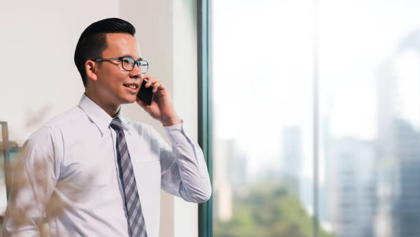 istock Asian Business man using smart phone on window with city building background and copy space. 691706576
