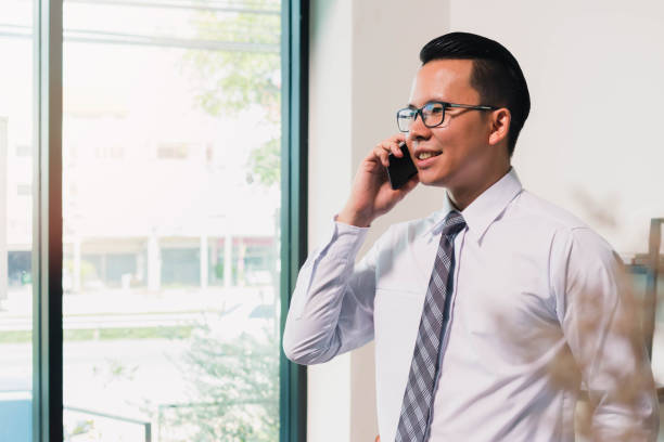 istock Asian Business man using smart phone on window in home office background 691706578
