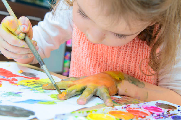 istock girl drawing paints on paper and hands 691709896