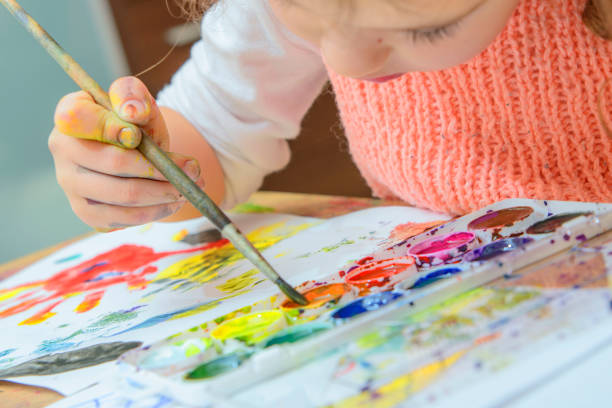 istock girl drawing paints on paper and hands 691709908
