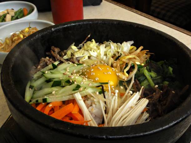 istock Bibimbap with raw egg and sesame in a hot stone pot 691710060