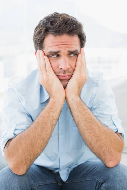 istock Sad man sitting on the couch looking away 691715380