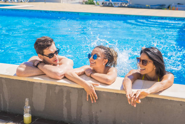 istock cheerful friends drinking cocktails in the pool 691716086
