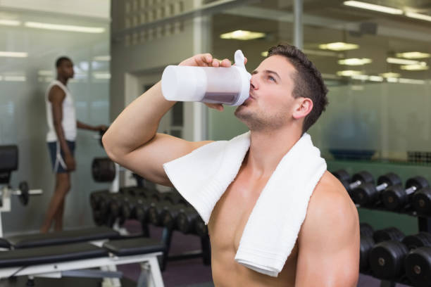 istock Shirtless bodybuilder drinking protein drink sitting on bench 691718766
