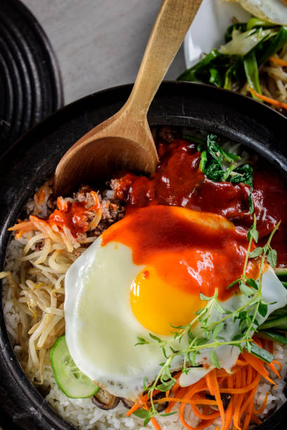 istock BI Bim Bap, Rice with Mixed Vegetables, top view with Hot Sauce in Cast Iron Pot 691718900