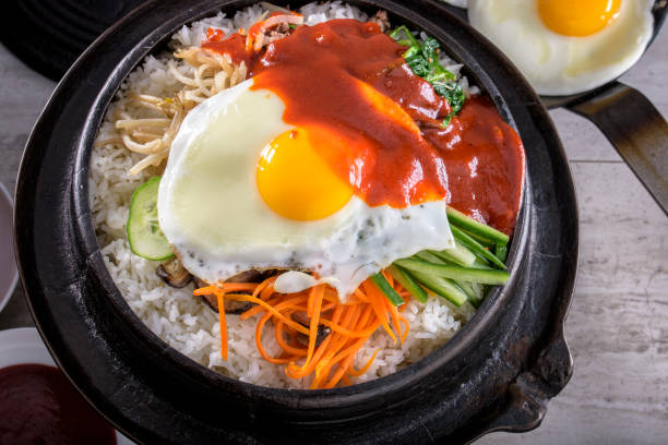 istock BI Bim Bap, Rice with Mixed Vegetables, top view with Hot Sauce in Cast Iron Pot 691718910