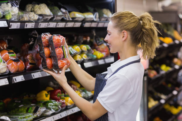 istock Side view of a smiling blonde worker taking a tomatoes 691719464