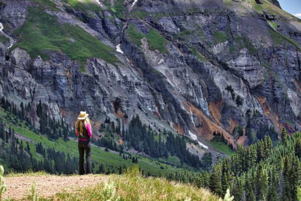 istock Long blonde haired young woman overlooking mountains 691723480