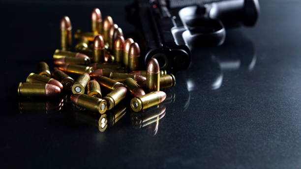 istock Bullets and a gun on black mirror 691726078