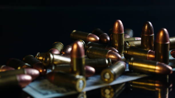 istock Bullets and US dollars bill on black mirror 691729278