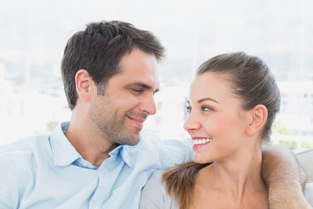 istock Couple sitting on the sofa smiling at each other 691730302