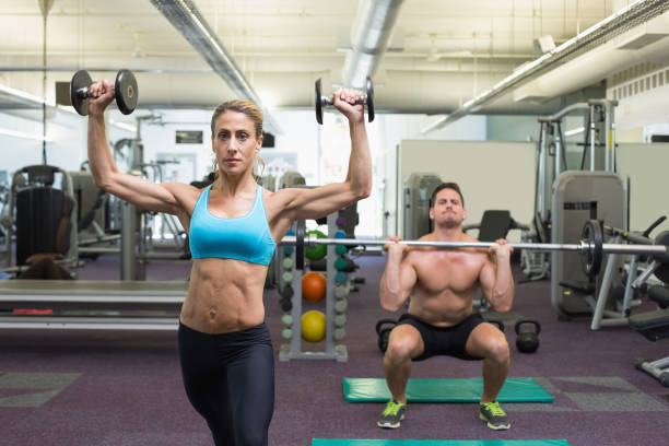 istock Muscular man and woman lifting weights 691738134