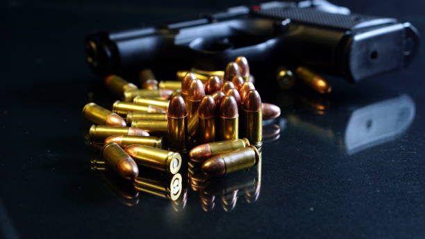 istock Bullets and a gun on black mirror 691740742