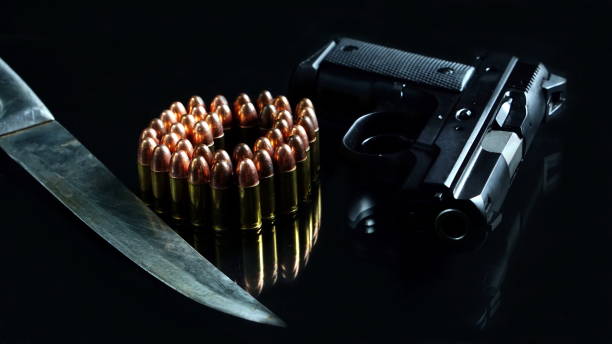 istock Bullets, knife and a gun on black mirror 691747590