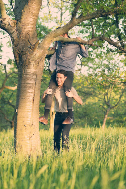 istock Young men have fun climbing a tree in summertime 691760702