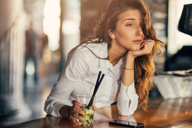 mujer bebiendo cócteles en un bar - drunk fotografías e imágenes de stock