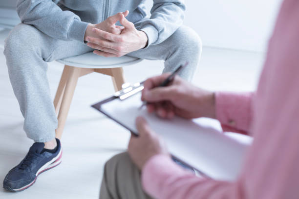 Psychologist taking notes Psychologist taking notes during meeting with his teenage patient self mutilation pictures stock pictures, royalty-free photos & images