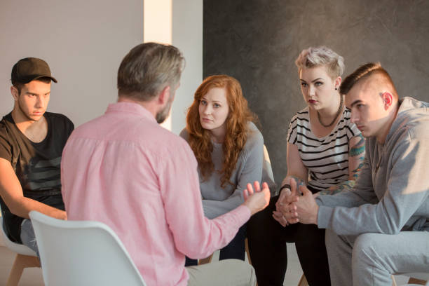 Addiction counselor and his patients Addiction counselor talking to group of his teenage patients self mutilation pictures stock pictures, royalty-free photos & images