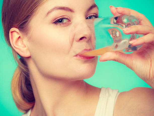 istock Woman drinking orange flavored drink or juice 691778810