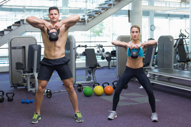 istock Bodybuilding man and woman lifting kettlebells 691781910
