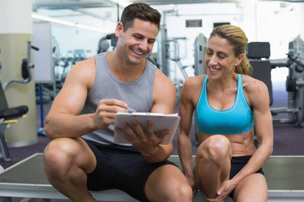 istock Female bodybuilder sitting with personal trainer talking 691784924