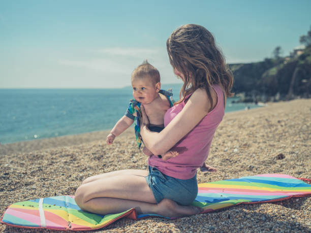 istock Woman with baby on beach 691786016