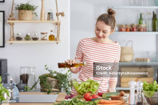 Woman Adding Olive To A Salad Stock Photo - Download Image Now - Cooking, Cooking Oil, Olive Oil