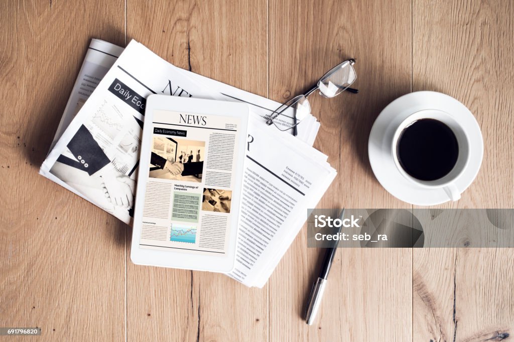 Newspaper with tablet on wooden table Newspaper Stock Photo