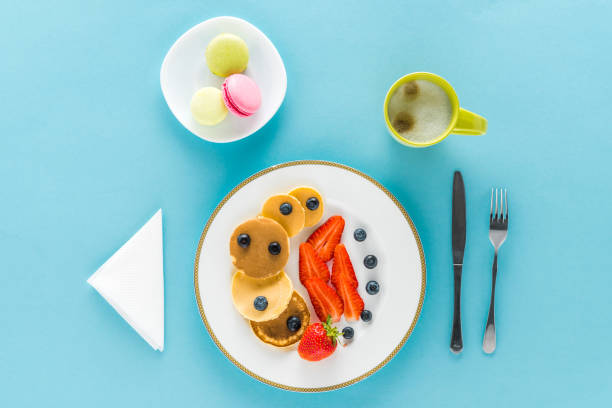 istock top view of pancakes with berries on plate with macarons on blue background 691814958